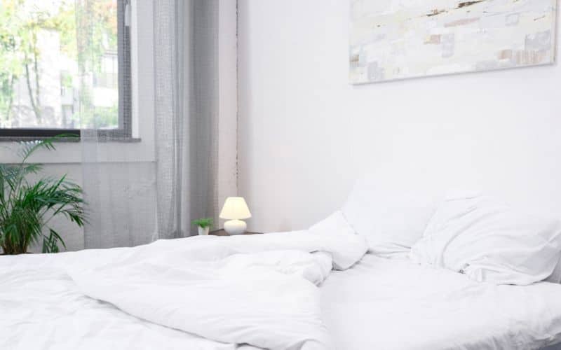 bed with a white sheet and white pillow