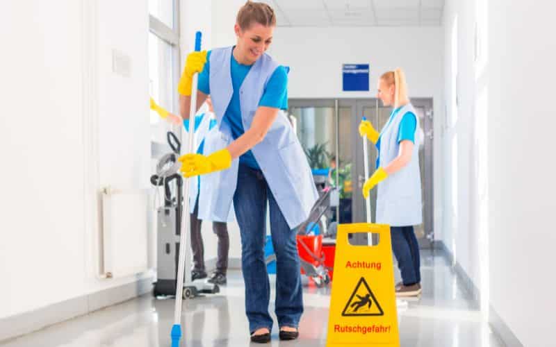 Cleaners diligently cleaning the floor using professional equipment