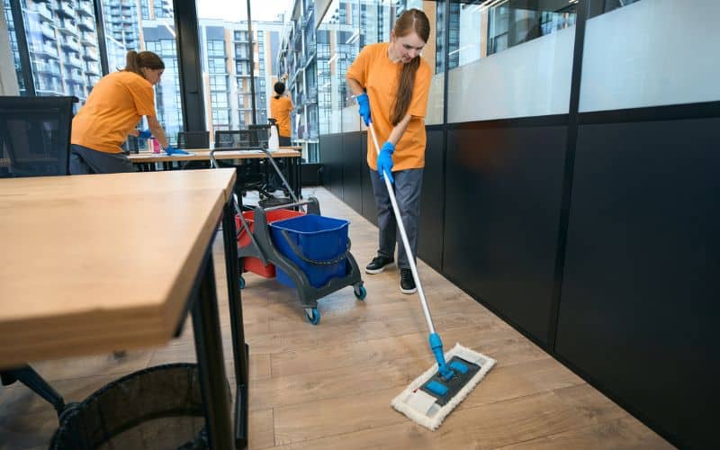 Team of cleaners work in coworking area